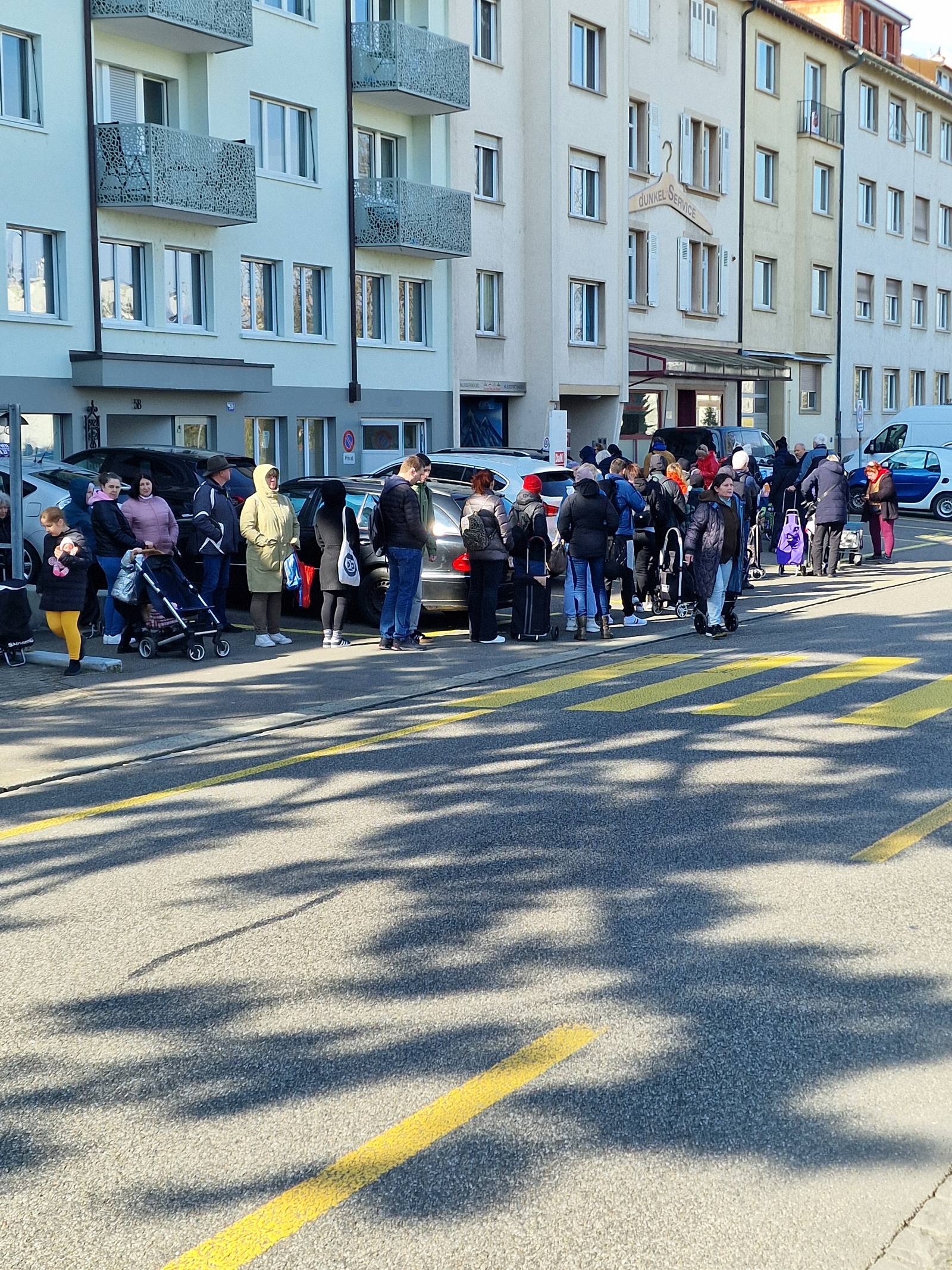 Menschen warten am Dienstag vor der Ausgabestelle an der Birsstrasse.